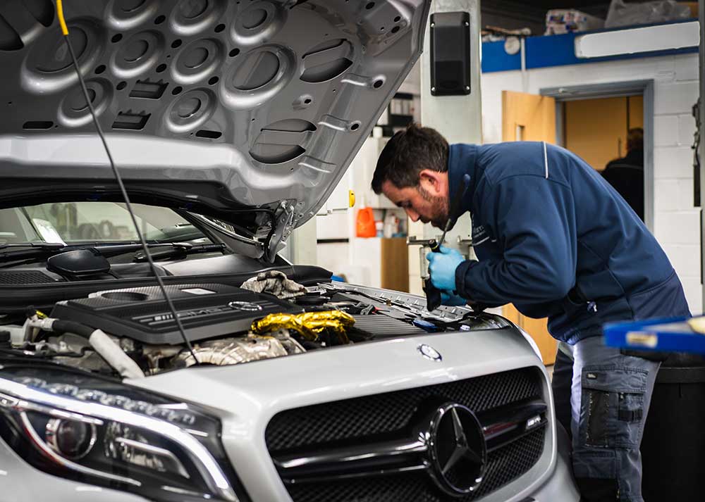 Professional technician servicing a Mercedes-AMG engine